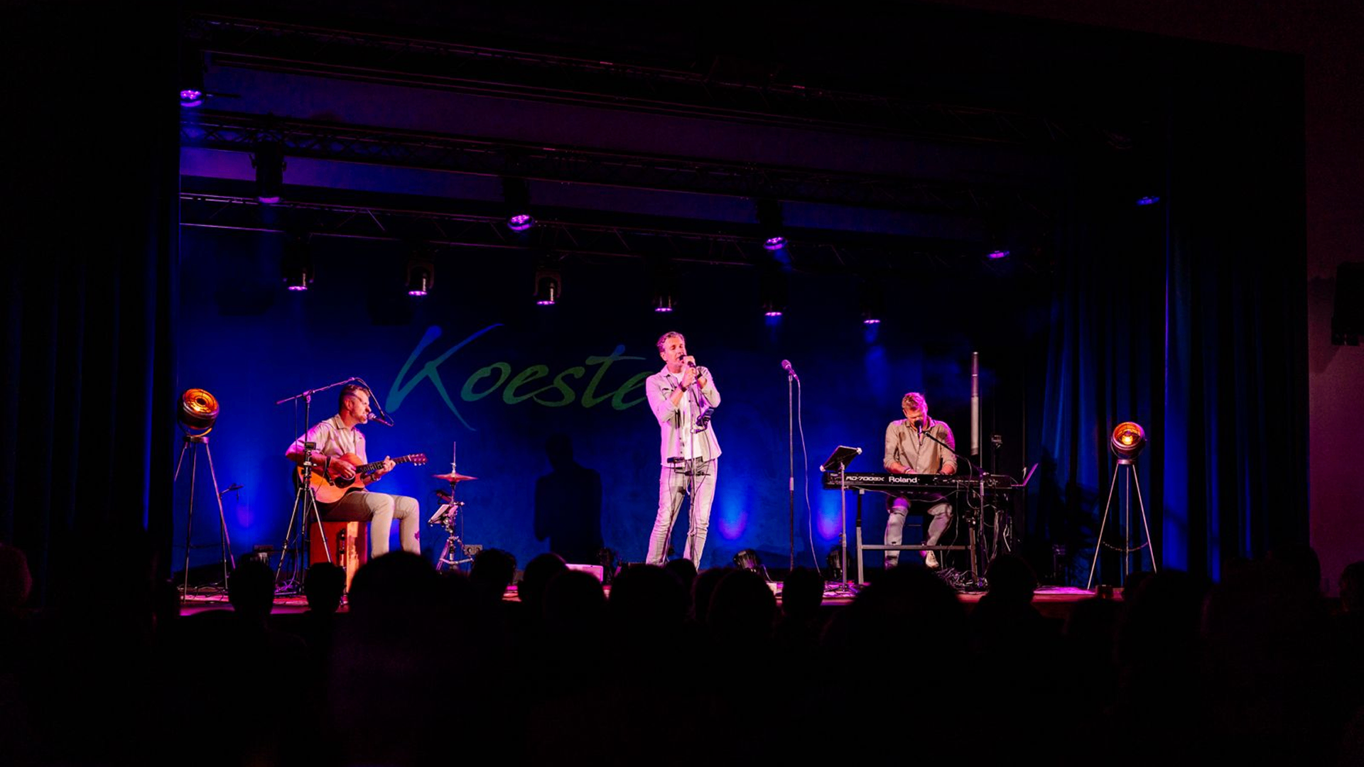 KOESTER als 3-mans live formatie op een verlicht podium in Leeuwarden